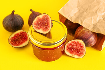 Jar of sweet fig jam on yellow background