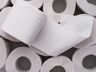 A toilet roll lying on top of heap of toilet paper rolls - obrazy, fototapety, plakaty