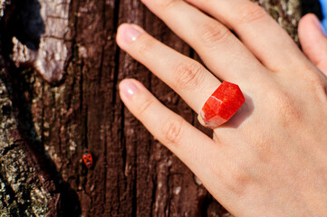 Wooden ring made of epoxy resin on a girl's hand. Women's jewelry made from natural materials.