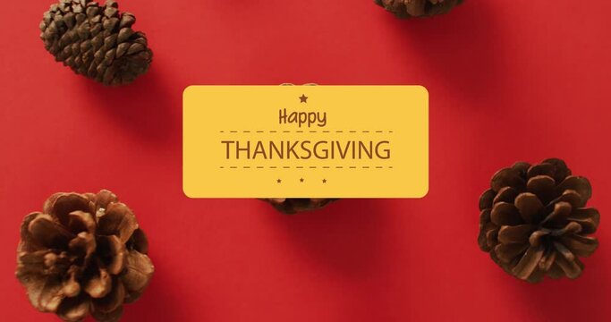 Animation of happy thanksgiving day over pine cones on red background