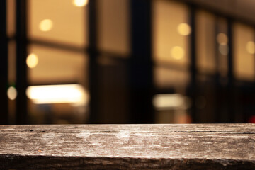 Empty dark wooden table in front of abstract blurred bokeh background of restaurant, window frames....