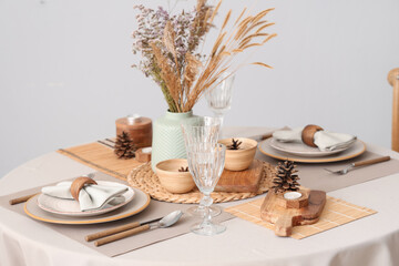 Elegant table setting with dried flowers, pampas grass and pine cones