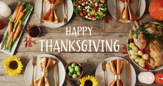 Animation of happy thanksgiving over dinner food on wooden background