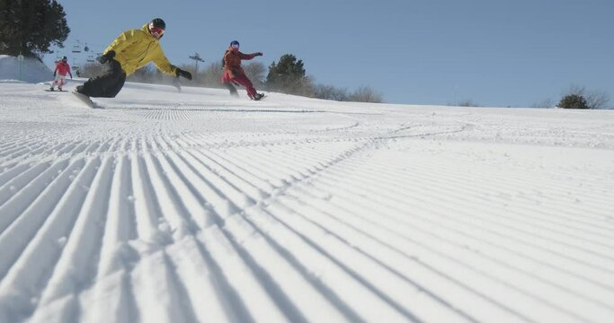 Snowboarders slide down ski snow track. Snowboarders students go down mountain. Day off weekends New Year's Christmas holidays spent at ski resort for snowboarding, professional extreme winter sports