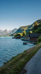 Boat mooring huts on the edge of the alpine mountain lake Wolfgangsee on a sunny summer day.