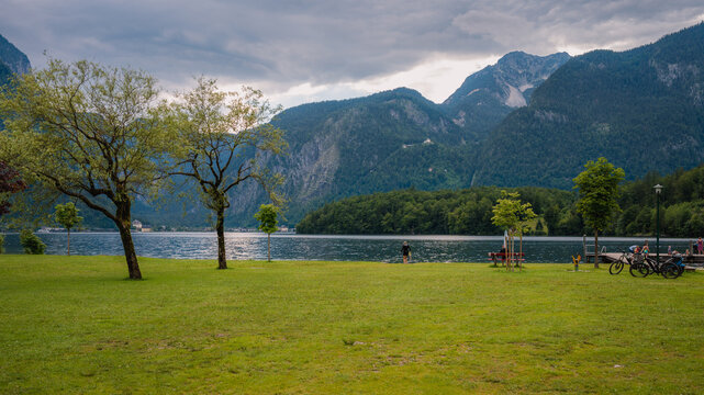View of Hallstätter See lake from Obertraun village. A grassy area with a playground on the shore of the lake with an amazing view of the mountains and the Austrian village of Hallstatt.