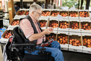 A man in a wheelchair shops at a local fruit stand for produce along the Columbia River Gorge in...