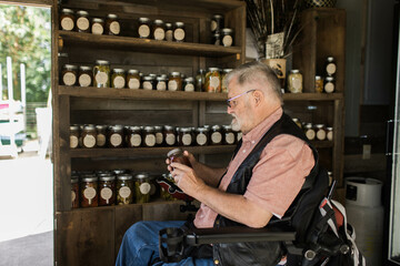 Fototapeta na wymiar A man in a wheelchair shops at a local fruit stand for produce along the Columbia River Gorge in Washington State.
