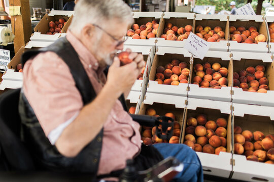 A man in a wheelchair shops at a local fruit stand for produce along the Columbia River Gorge in Washington State.