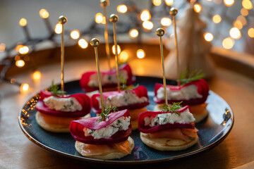 Christmas canapes with blinis with salmon, pickled beetroot and goat cheese - obrazy, fototapety, plakaty