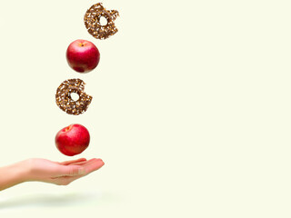 Flying levitating floating red ripe fresh apples with sweet glazed doughnut,donut in air above...