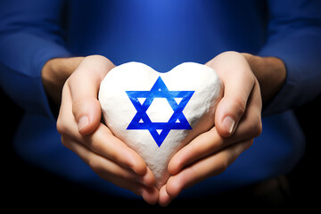 female hands holding white heart with blue star of david