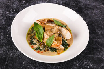 Chicken fillet with spinach and sun-dried tomatoes in coconut milk.