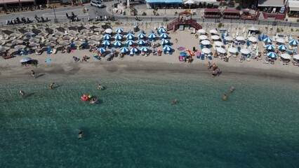 Fototapeta na wymiar Aerial drone view parga greece, beach crowded with tourists in vacation on summer in famous greek caribbean parga town epirus preveza