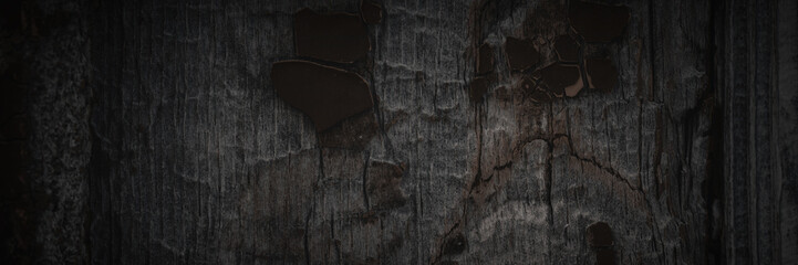 Texture of old weathered rough cracked wood surface with peeling paint. Dark wide panoramic background for design. Shaded vintage texture with vignette.