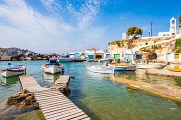 Fototapeta na wymiar Colorful fishing boats on azure sea water in Mandrakia port, Cyclades, Milos island, Greece