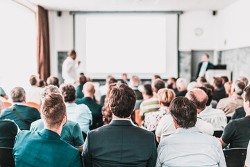 I have a question. Group of business people sitting at the chairs in conference hall. Businessman standing up asking a question. Conference and Presentation. Business and Entrepreneurship. - obrazy, fototapety, plakaty