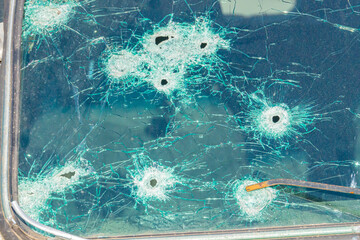 bullet wounds on a car window. gun attack on a car. gangs and conflicts. background bullet hole glass abstract crime gun shot