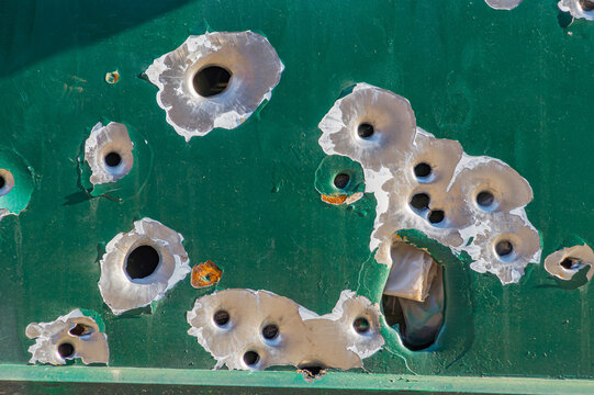 bullet holes, texture, metal, shooting, shooting on the street, shot, target, bullet, grapeshot, gunpowder, background. bullet holes in the metal. multiple bullet marks on the car body. peeling green