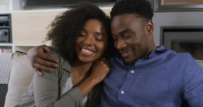 Relax, happy and couple on sofa in home for bonding, healthy relationship and talking together. Love, dating and African man and woman on couch embrace, hugging and smile in living room for affection
