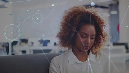 Animation of network of connections against african american woman using smartphone at office - Powered by Adobe