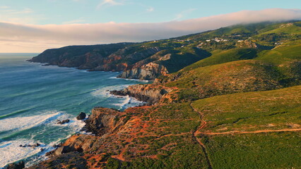 Sunny ocean coastal landscape drone view. Sea splashing shoreline washing stones