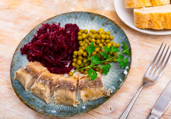 Cold smoked mackerel with grated beetroot and green peas served in a plate with other table...