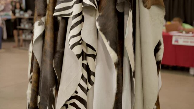 This video shows a display of faux animal skins rugs hanging.