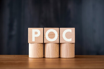 There is wood cube with the word POC. It is an abbreviation for Proof of Concept as eye-catching image.