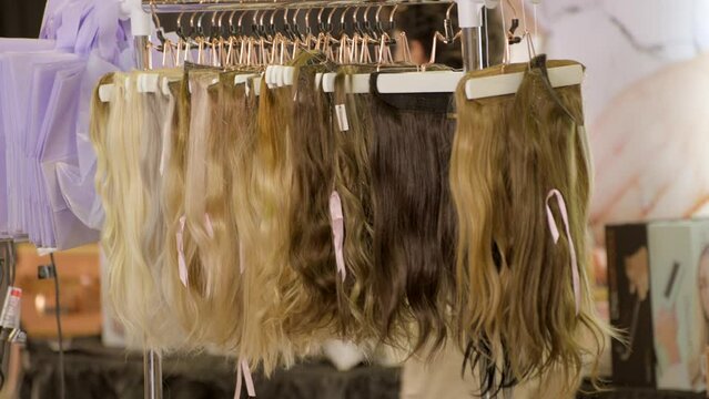This video shows a rack of wigs hair extension on display.