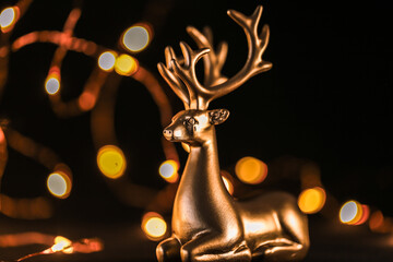 Christmas glowing wallpaper with deer and golden bokeh on a black background.Beautiful holiday...