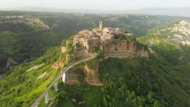 Aerial summer evening view of famous Civita di Bagnoregio town, beautiful place located on top of a volcanic tuff hill overlooking the Tiber river valley. The place has Etruscan and Medieval origins.