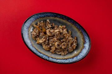 Buckwheat Porridge with Mushrooms on a Red Plate
