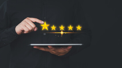 Hand using a tablet give point five stars icon for feedback review satisfaction service opinion and testimonial - obrazy, fototapety, plakaty