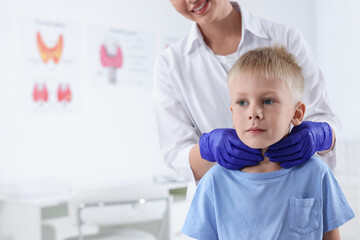 Endocrinologist examining boy's thyroid gland at hospital, closeup. Space for text