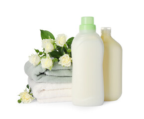 Obraz na płótnie Canvas Bottles of fabric softener, stacked clean towels and beautiful flowers isolated on white