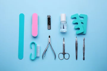 Abwaschbare Fototapete Set of pedicure tools on light blue background, flat lay © New Africa