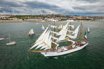 Aerial drone view of tall ships with sails sailing in Tagus river towards the Atlantic ocean in...