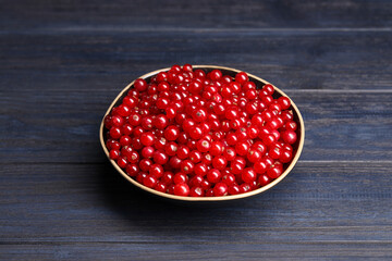 Ripe red currants in bowl on wooden rustic table