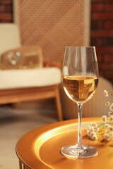 Glass of white wine on table in room, space for text. Relax at home