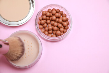 Applying face powder on brush on pink background, flat lay. Space for text