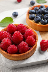 Tartlet with fresh raspberries on table, closeup. Delicious dessert
