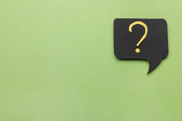 Paper speech bubble with question mark on green background, top view. Space for text