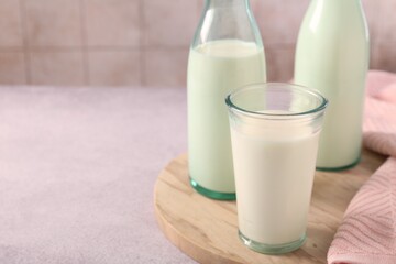 Glassware with tasty milk on table, closeup. Space for text