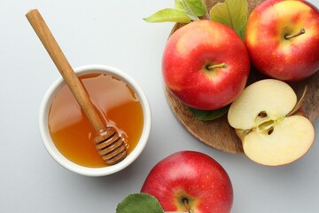 Sweet honey and fresh apples on white table, flat lay