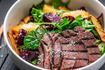 Salad with roast beef and caramelized beets with orange fillet, potatoes, parmesan, salad mix and olive oil - obrazy, fototapety, plakaty