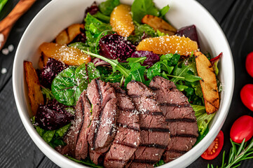 Salad with roast beef and caramelized beets with orange fillet, potatoes, parmesan, salad mix and olive oil