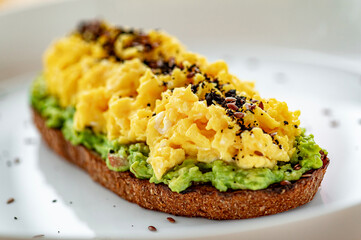Scrambled on toast with guacamole and olives