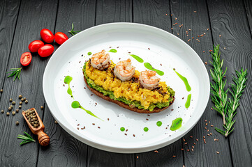 Scrambled on toast with guacamole, shrimp and olives