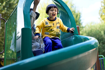 滑り台で遊ぶ子供/ Child playing on the slide